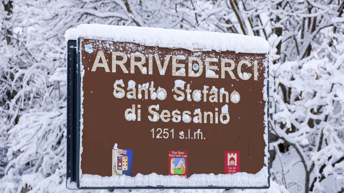 Snow-covered sign at Santo Stefano di Sessanio, showcasing a winter wonderland.